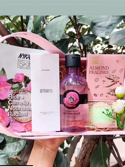 This beautiful pink basket hamper is perfect for a sister. It includes a Nykaa sheet mask, The Body Shop shower gel, perfume, and almond pralines, all elegantly arranged.