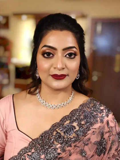 A frontal portrait showing the classic makeup look: defined eyes, bold lips, and a clean base.