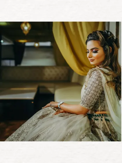 A serene portrait of the bride, seated gracefully. The soft lighting and her contemplative expression create a beautiful, artistic image.