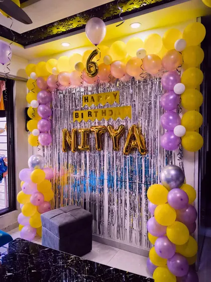 A yellow and purple balloon arch for a 6th birthday, creating a bright and cheerful party atmosphere.