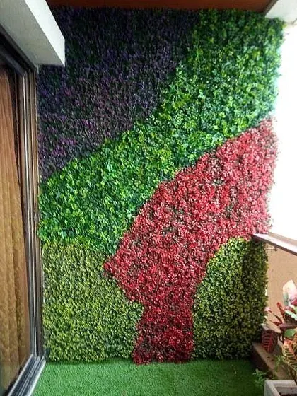 You are not limited to just green. For this balcony wall, I created a custom abstract design using green, purple, and red artificial foliage panels. If you can imagine it, I can create it.