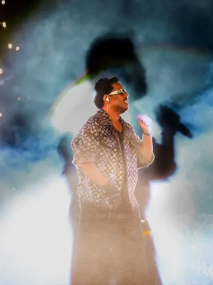 A creative shot capturing the artist on stage with sparklers and smoke, creating a high-energy, memorable image.