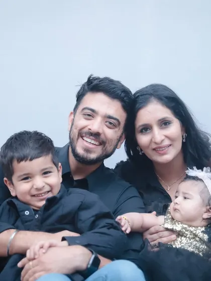 A beautiful family portrait with everyone smiling. A perfect example of a classic studio family photo.