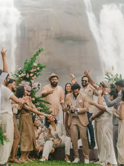 A moment of pure celebration with friends and family by the falls. The couple is surrounded by cheers and joy, a perfect candid shot capturing the spirit of the day.