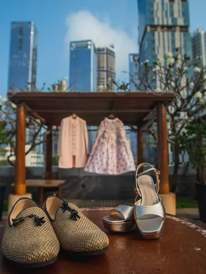 A creative shot of the couple's wedding outfits and shoes, displayed against the Mumbai city skyline. A unique way to document your wedding details.