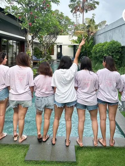 A shot from the back, showing the custom "Bride" and "Bridesmaid" text on the matching bachelorette party t-shirts. It's all about those picture-perfect moments.