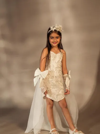 This full length view shows the high low hemline of the white dress, perfect for dancing and playing.