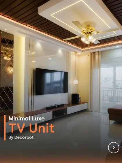 This minimal luxe TV unit features a stunning combination of a glossy white panel with gold inlay and a rich wood-paneled false ceiling. It’s a design that exudes sophistication and warmth.
