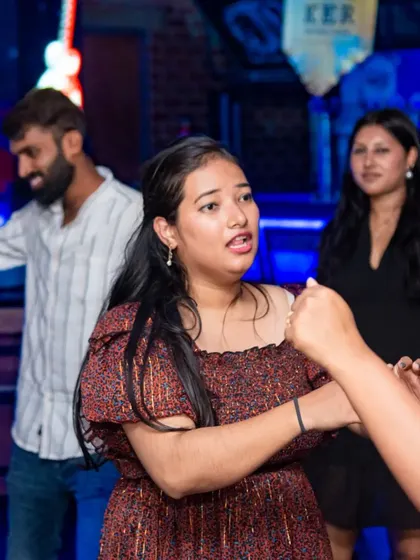 A candid moment on the dance floor. Guests enjoying the music and the company, lost in the vibrant, blue-lit atmosphere of the pub.