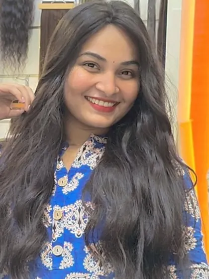 A happy smile from a client feeling confident and beautiful with her new wavy, long hair.