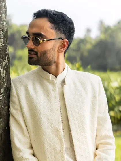 A close-up of the groom looking effortlessly cool in his sunglasses and stylish wedding attire.