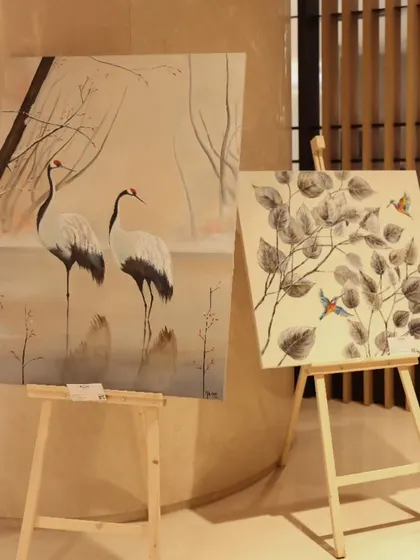 Two paintings by Malika Vijay from 'Nature's Symphony', featuring elegant cranes and birds, displayed at the Conrad Bengaluru.