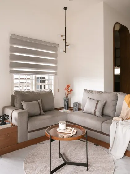 A custom-built L-shaped sofa with unique leather strap details provides ample seating in this living room. The design merges craftsmanship with function, creating a cohesive and sophisticated environment.