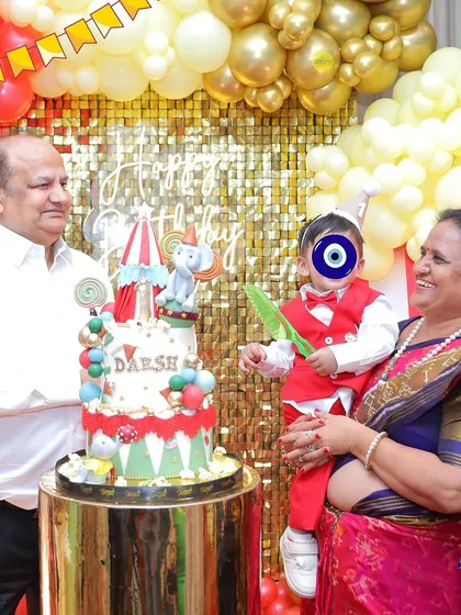 A sweet moment with the grandparents at the cake-cutting ceremony. The custom carnival-themed cake was a centerpiece of the celebration.