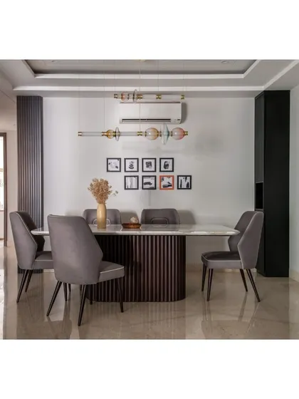 In this dining room, our 6-seater table with a white Statuario marble top and fluted oak wood base is the centerpiece. The design is minimalist yet functional, creating a perfect harmony of form and utility.