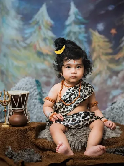 Om Namah Shivaya. This portrait captures the innocent yet powerful presence of a child dressed as little Lord Shiva, complete with traditional accessories and a mystical forest backdrop.