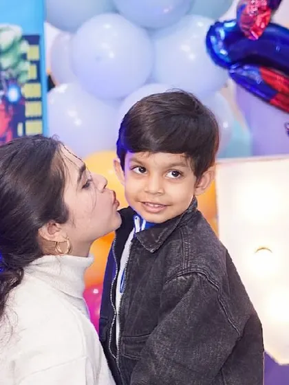 A sweet moment between a mother and her son at his superhero-themed party.