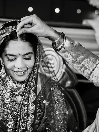 The sacred sindoor moment, captured in timeless black and white. The bride's serene expression is the focus of this powerful image.