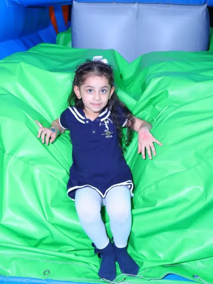 A young guest enjoys the soft and bouncy landscape of our green inflatable zone.