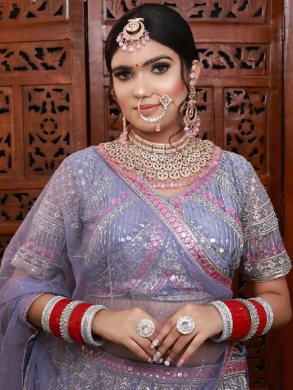 A modern bridal look featuring a pastel lehenga and diamond jewelry. The makeup is clean and sophisticated, with a focus on a flawless base and softly defined eyes.