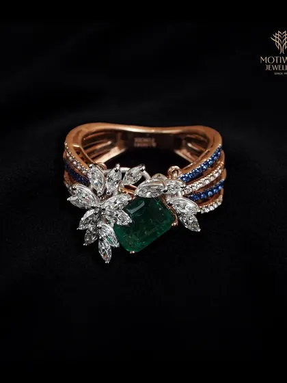 A symphony of gemstones, this ring combines a central emerald with flanking diamonds and sapphires. The unique color combination and floral motif make it a work of art.