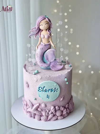 A dreamy purple mermaid cake for a 4th birthday. The delicate details, like the bubbles and seashells, create a magical underwater world for this beautiful mermaid topper.