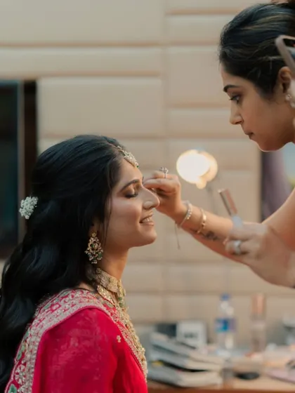 A candid moment during the makeup application process, showing the trust and rapport I build with my brides.