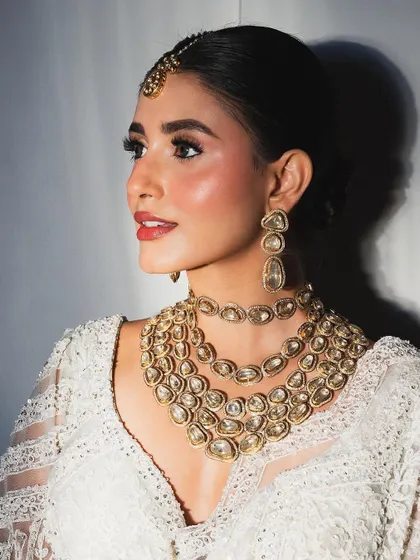 A classic engagement look with dewy skin, a soft red lip, and timeless gold jewelry.