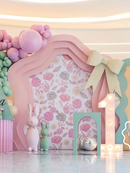 Welcome to "Aahana's Onderland," a whimsical first birthday party where every detail was crafted to inspire wonder. This custom-fabricated backdrop, with its soft pastel balloons and floral-print panels, set the stage for a magical celebration.