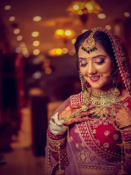 A beautiful three-quarter portrait of a bride, admiring her intricate henna and jewelry.