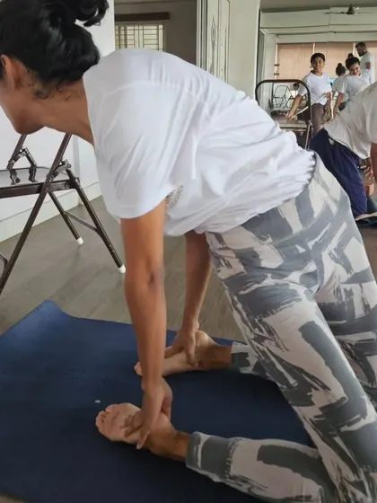This image shows a student in a supported supine twist, a restorative variation taught in our TTC to release spinal tension and calm the nervous system.