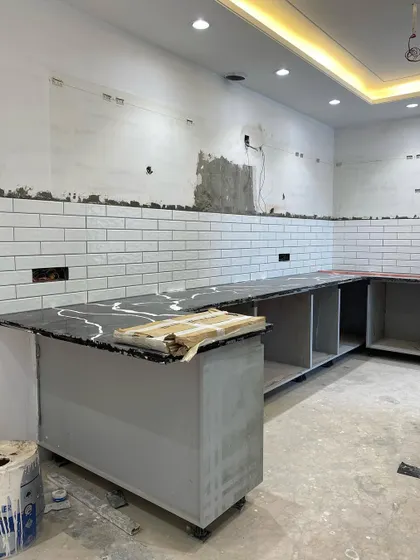 The L-shaped countertop is installed, and the base modules are in place. This image captures the crucial middle stage of our kitchen renovation process before the shutters and final fittings are added.