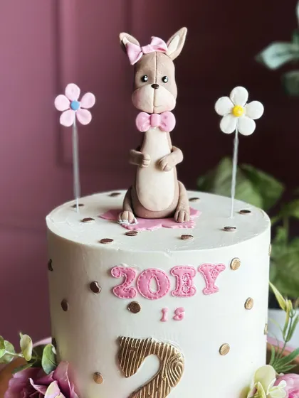 Two sweet to handle! This adorable second birthday cake features a cute kangaroo topper and delicate floral details for a charming and fun celebration.
