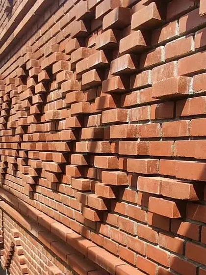 A close-up of the 'Kasuti' brickwork, highlighting the three-dimensional texture and the play of light and shadow.