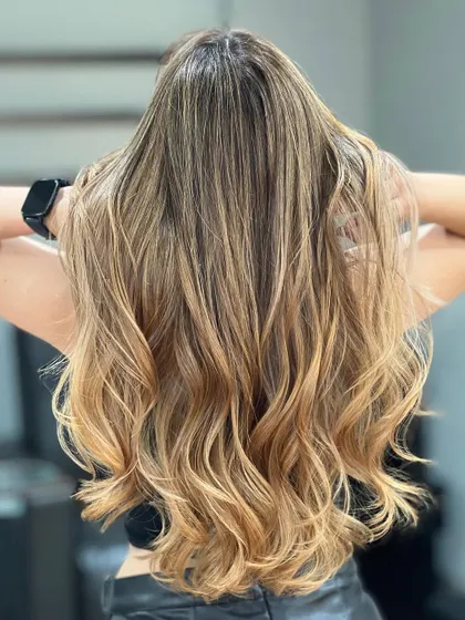 The back view of this blonde Airtouch Balayage shows the perfect, seamless blend of art and technique. The hair looks healthy, shiny, and stunning.