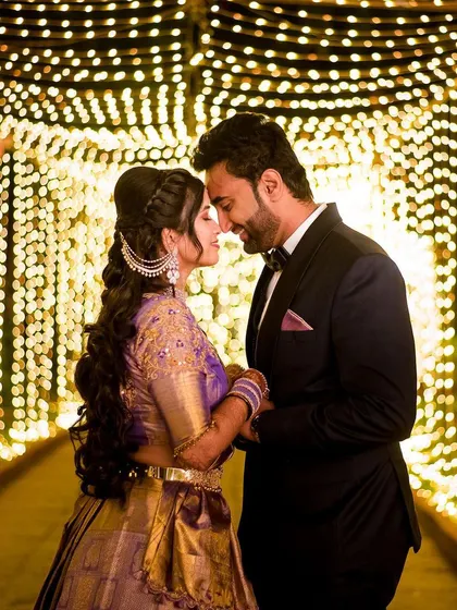 A magical moment for the couple, framed by a tunnel of fairy lights. We love creating these cinematic shots that feel like they are straight out of a movie, perfect for your reception or sangeet night.