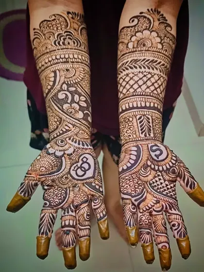 This engagement design features the couple's initials, 'S' and 'G', each inside a heart. The surrounding mehandi is a mix of bold, modern patterns and delicate traditional fillers.