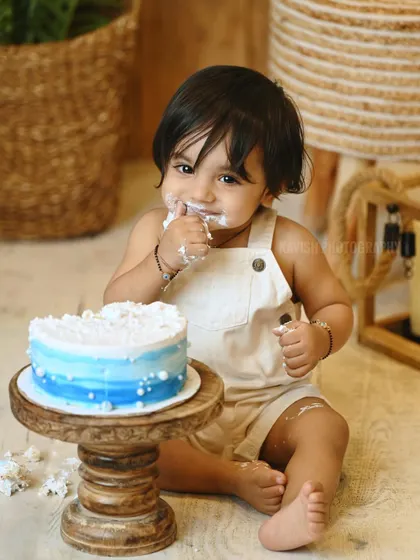 A sweet portrait of the baby mid-celebration during his cake smash photoshoot.