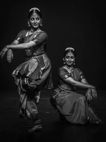 A dramatic black and white photograph of a duet. The stark contrast highlights the form and lines of the dancers, showcasing the sculptural quality I strive for in my choreography.