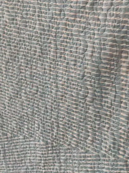 A close-up of the backing fabric, showing the texture of the longarm quilting.