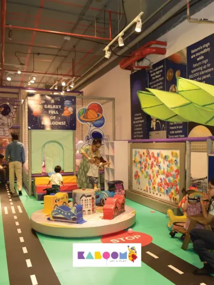 A wider view of our play space, showing the road-themed floor, various ride-on toys, and different activity zones designed to spark imagination.