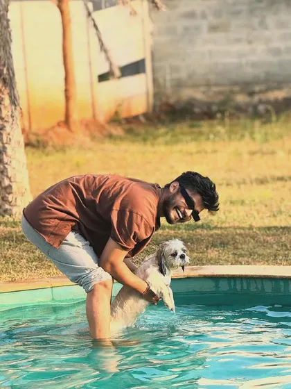Capturing a moment of pure fun as this dog gets a gentle lift into the water.