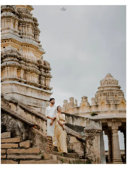 A majestic shot of a couple standing on the steps of an ancient temple. The grandeur of the architecture elevates their portrait, making it feel truly epic.