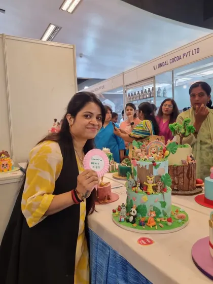 Holding up a "Happy Birthday" sign next to my cake. Even though it was for a competition, I always design my cakes with a celebration in mind.