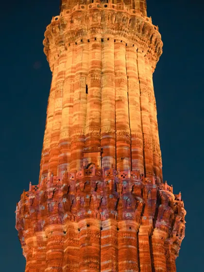 A detailed shot of the intricate carvings on Qutub Minar, glowing under the evening lights. The craftsmanship is simply incredible.