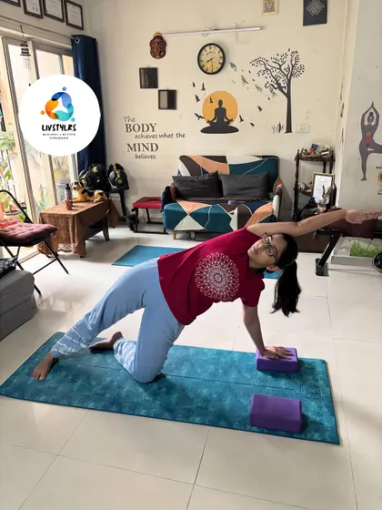 Using yoga blocks for support in a modified Vasisthasana (Side Plank Pose). This builds oblique strength and shoulder stability while making the pose accessible to different levels.