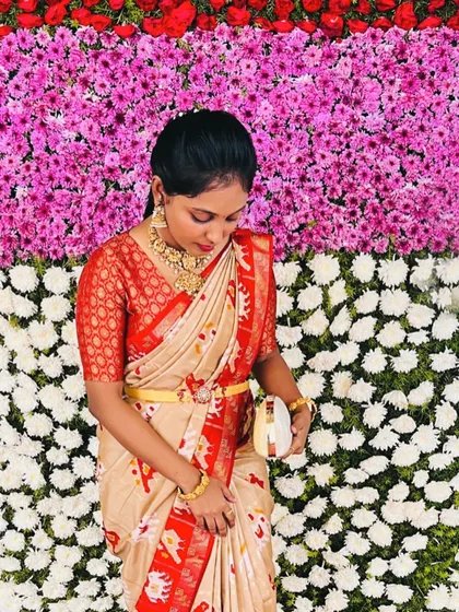 Our lovely client Punitha looking pretty as a flower against a floral wall in her patola silk saree and red brocade blouse.