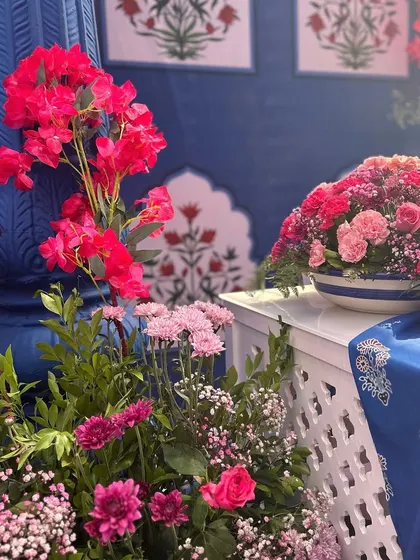 A close-up of the vibrant floral arrangements, with bright pink flowers contrasting beautifully against the blue and white decor elements.