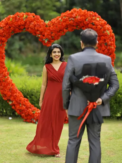 A playful and romantic pre-wedding moment, as the groom surprises the bride with a bouquet of roses.