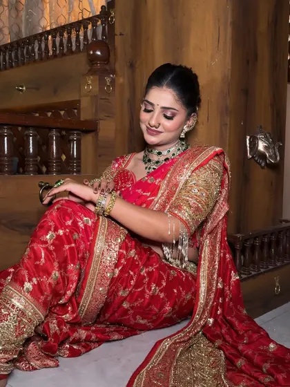 A relaxed pose in a traditional red bridal saree. My draping ensures the bride looks graceful whether she is standing, sitting, or dancing.